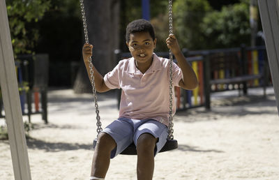 Boy swinging at playground