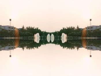 Reflection of building in lake against clear sky