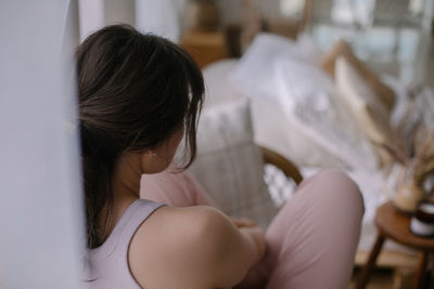 Close-up of woman sitting at home