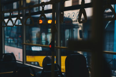 Man sitting on vehicle seat by window in bus