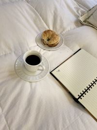 High angle view of coffee and journal on  bed