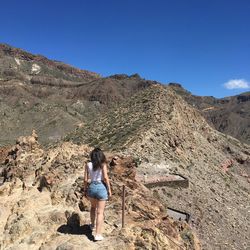 Full length of woman walking on rock against sky