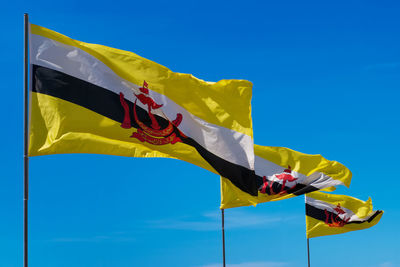 Three flags poles of brunei darussalam on sky background