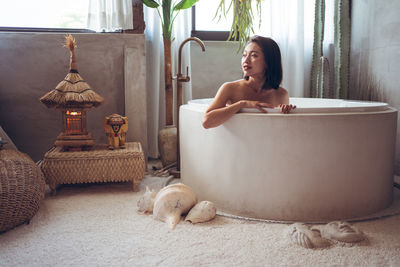 Woman sitting in bathroom