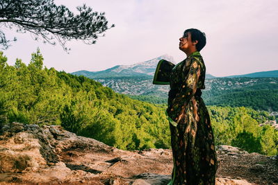 Mature woman wearing kimono while standing on mountain