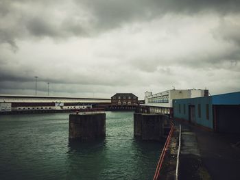 Bridge over river against cloudy sky