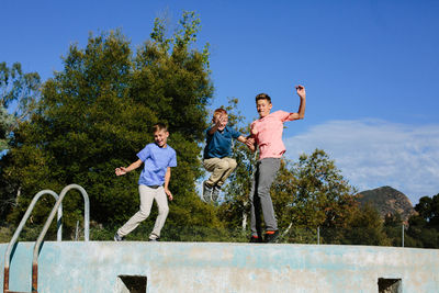 Brothers jump in the air in the direct sunlight