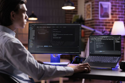 Side view of man using laptop