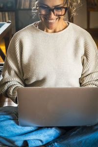 Portrait of young woman using laptop at home