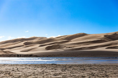 Scenic view of beach against blue sky