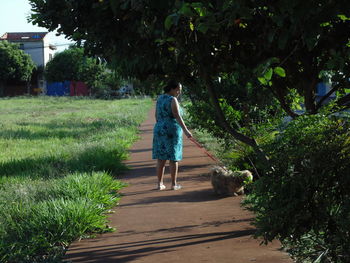 Rear view of woman walking on footpath