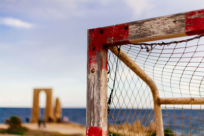 Close-up of wooden fence on beach against sky