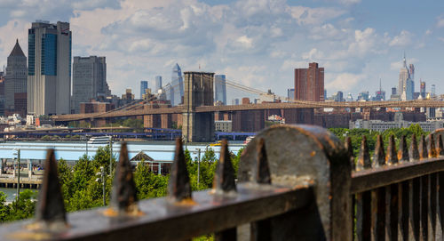 Bridge and buildings in city against sky