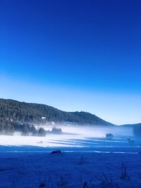 Scenic view of snowcapped mountains against blue sky