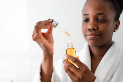 Close-up portrait of woman holding bottle