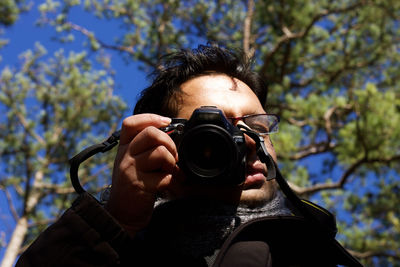 Low angle view of person holding camera and taking picture 