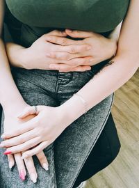 Low section of man holding woman sitting