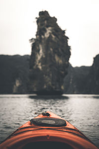 Boat on rock by lake against sky