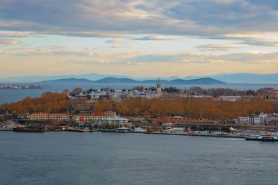 Scenic view of sea and buildings against sky during sunset