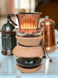 Close-up of coffee cup on container on table