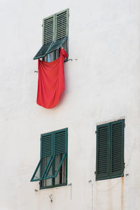 Low angle view of red umbrella against built structure