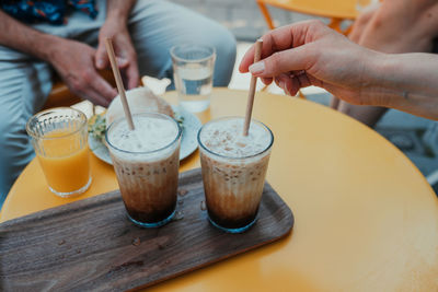Midsection of man holding coffee cup on table