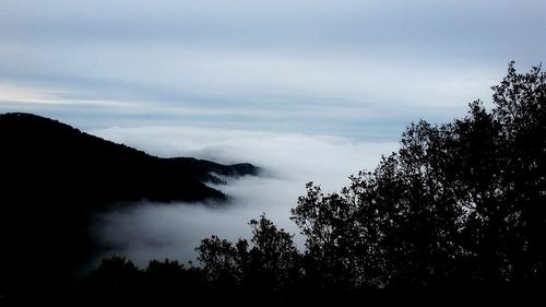 Scenic view of mountains against cloudy sky