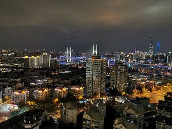 High angle view of illuminated city against sky at night