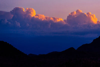 Scenic view of silhouette mountains against sky at sunset