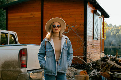 Portrait of young woman wearing sunglasses standing outdoors