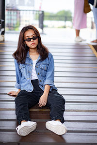 Portrait of young woman sitting on floor