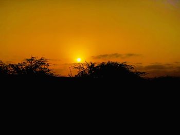 Scenic view of silhouette landscape against orange sky