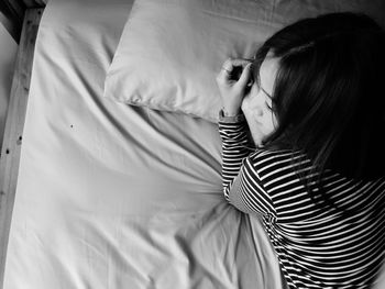 Rear view of woman relaxing on bed at home