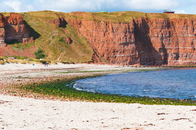 Scenic view of rocks by sea against sky