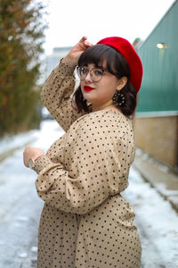 Portrait of young woman standing outdoors during winter