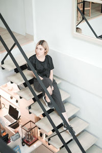 Portrait of young woman standing on steps