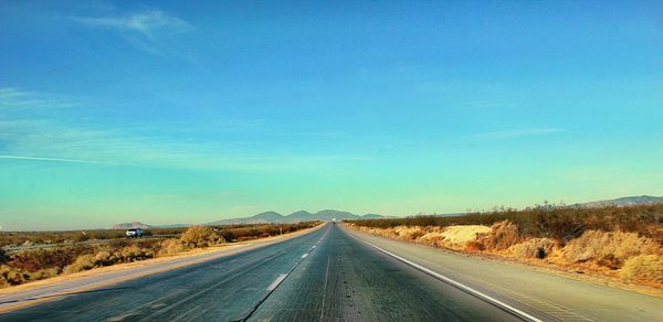 Empty road along countryside landscape