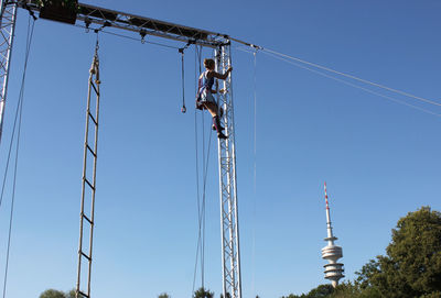 Low angle view of crane against clear blue sky