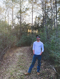 Portrait of young man standing in forest