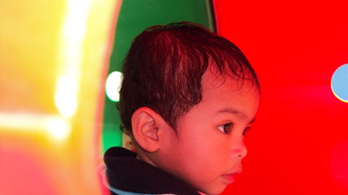 Close-up of boy looking away while playing in tube slide