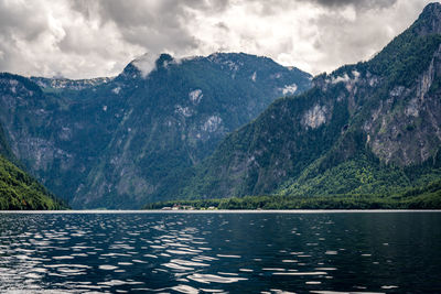 Scenic view of lake by mountains against sky