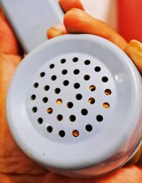 High angle view of human hand on an object, an old vintage blue telephone speaker