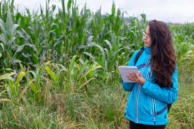 Rear view of woman standing against plants