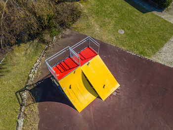 High angle view of yellow arrow symbol on grass in park