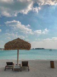 Chairs on beach against sky