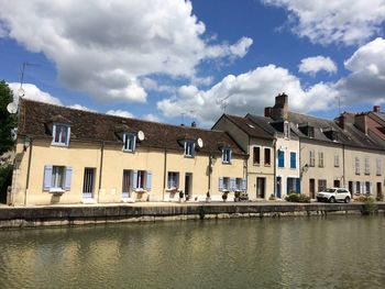 Buildings in city against cloudy sky