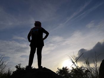 Low angle view of silhouette man standing against sky during sunset