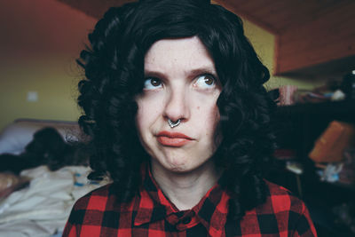 Close-up of young woman wearing nose ring at home