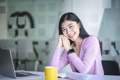 Portrait of a smiling young woman using mobile phone