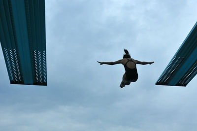 Low angle view of man flying against sky